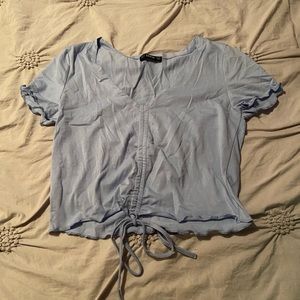 Blue short sleeve crop top with adjustable cinching at the bottom